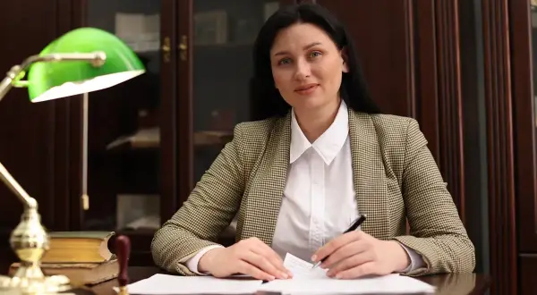 Radca prawny przy biurku, analizuje dokumenty. Zastanawia się, ile zarabia radca prawny w swojej specjalizacji.