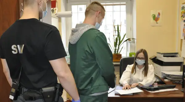 Strażnik więzienny i osadzony przed urzędniczką. To scena z życia sądu penitencjarnego, gdzie rozpatrywane są wnioski skazanych.